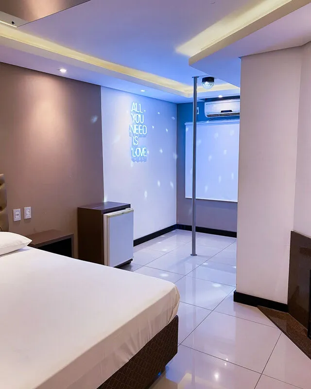 Suíte ampla com cama de casal e iluminação em LED no Motel San Rafael